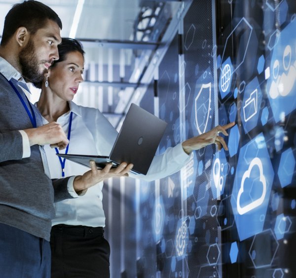 Male IT Specialist Holds Laptop and Discusses Work with Female Server Technician. They're Standing in Data Center, Rack Server Cabinet with Cloud Server Icon and Visualization.